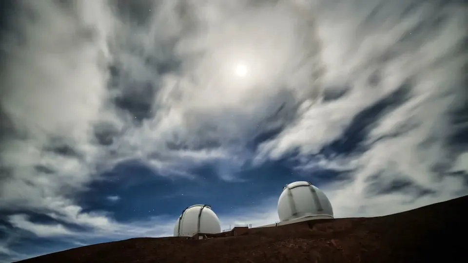 The twin Keck Observatory domes under a moonlit sky on Maunakea